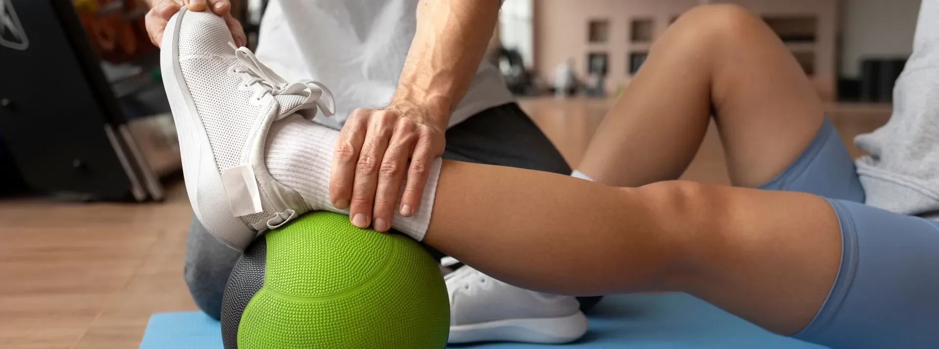 Individual engaging in a leg exercise with a ball at Attwood & Associates, a physiotherapy clinic in Hermanus, South Africa.