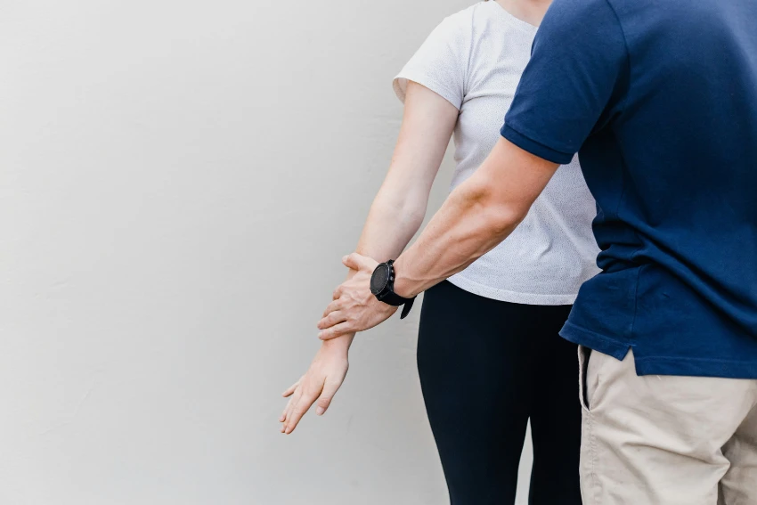 A man and woman stand together, participating in a Neurological Rehabilitation program at Attwood & Associates in Hermanus, South Africa.
