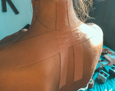 Physiotherapist instructing a client on functional movement retraining for spinal strength.